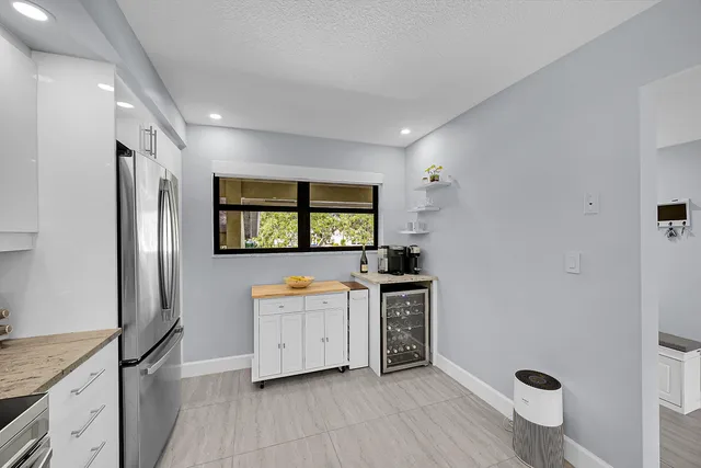 a kitchen with stainless steel appliances granite countertop a refrigerator a sink a stove and wooden floors