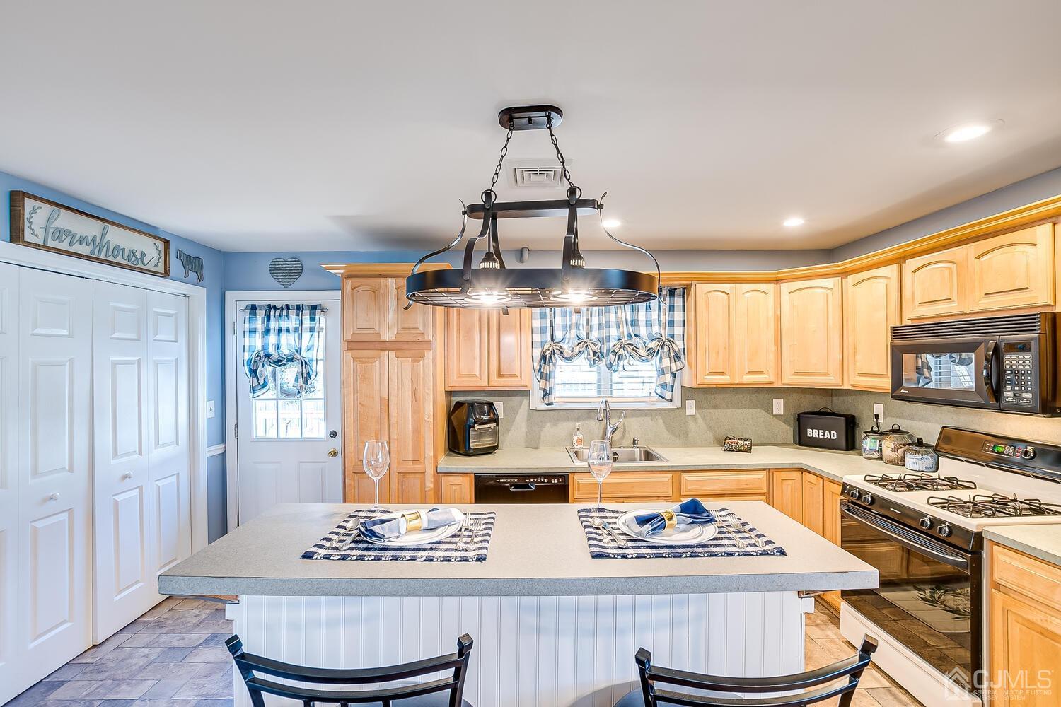 50 Old Post Road Edison, NJ 08817 - Photo 14 of 39 a kitchen with stainless steel appliances a stove a sink dishwasher and white cabinets with wooden floor