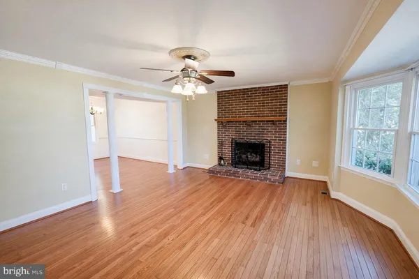 a living room with wooden floor and a fireplace