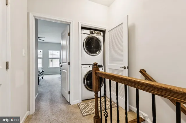 a view of a hallway and a washer and dryer to ceiling window