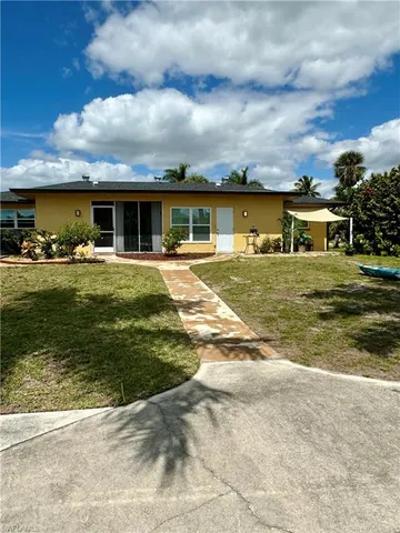 a front view of house with yard outdoor seating and barbeque oven