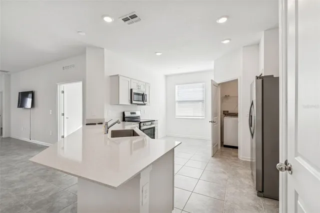a kitchen with white cabinets and stainless steel appliances
