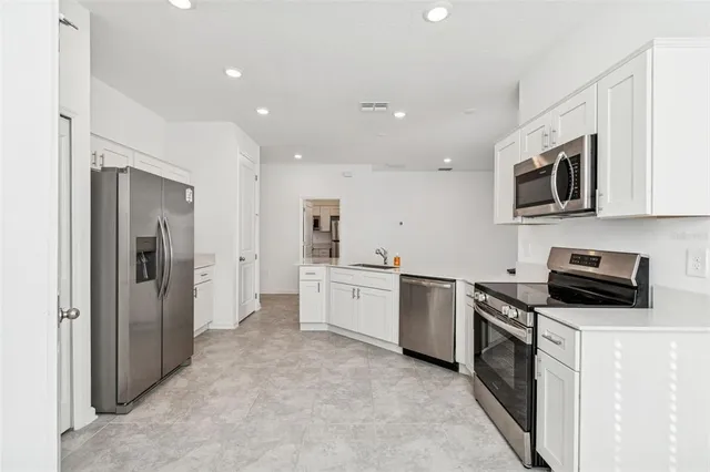 a kitchen with stainless steel appliances a refrigerator sink and cabinets