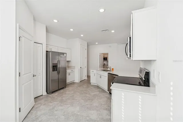 an empty room with windows and cabinet