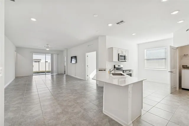 a kitchen with stainless steel appliances granite countertop a sink stove and cabinets