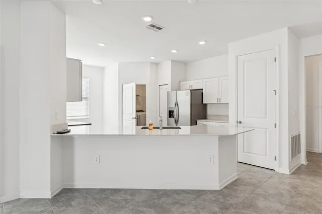 a kitchen with stainless steel appliances granite countertop a refrigerator and a sink