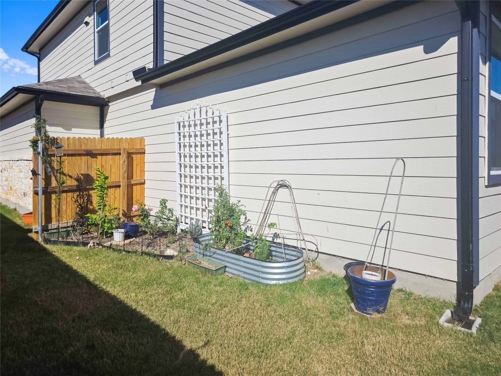 410 Inks Lane Kyle, TX 78640 - Photo 18 of 20 View of property exterior featuring a garden