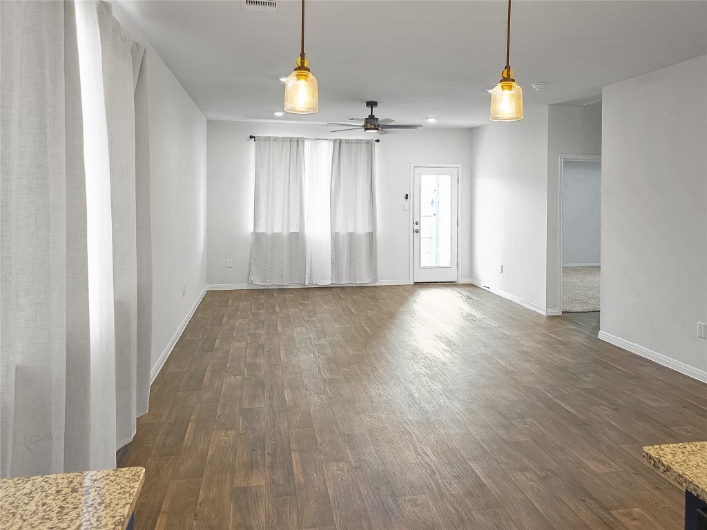 410 Inks Lane Kyle, TX 78640 - Photo 6 of 20 Unfurnished living room featuring dark wood-type flooring and ceiling fan
