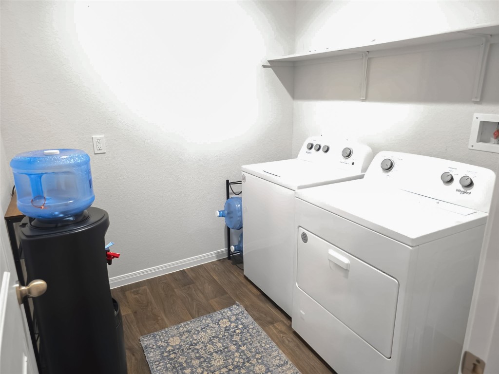 410 Inks Lane Kyle, TX 78640 - Photo 7 of 20 Laundry room with dark wood-style flooring, washer and clothes dryer, and a textured wall