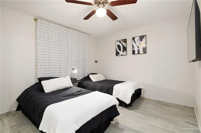 a bedroom with two beds and painting on the wall