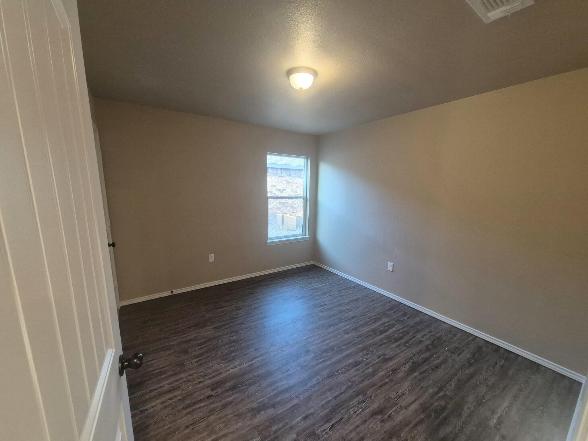 2506 Avenue P Lubbock, TX 79411 - Photo 11 of 11 an empty room with wooden floor and windows