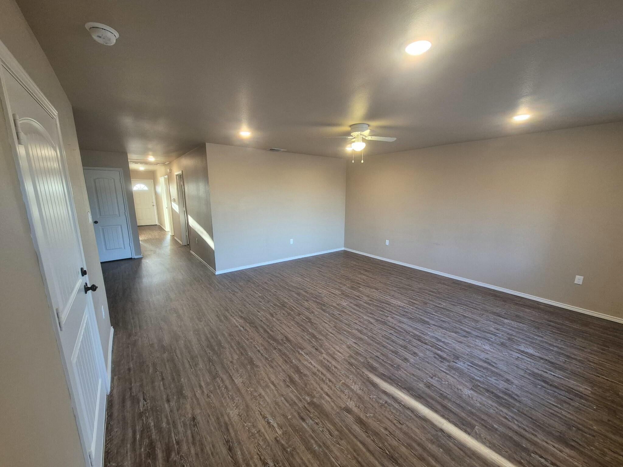 2506 Avenue P Lubbock, TX 79411 - Photo 3 of 11 an empty room with wooden floor and a hallway