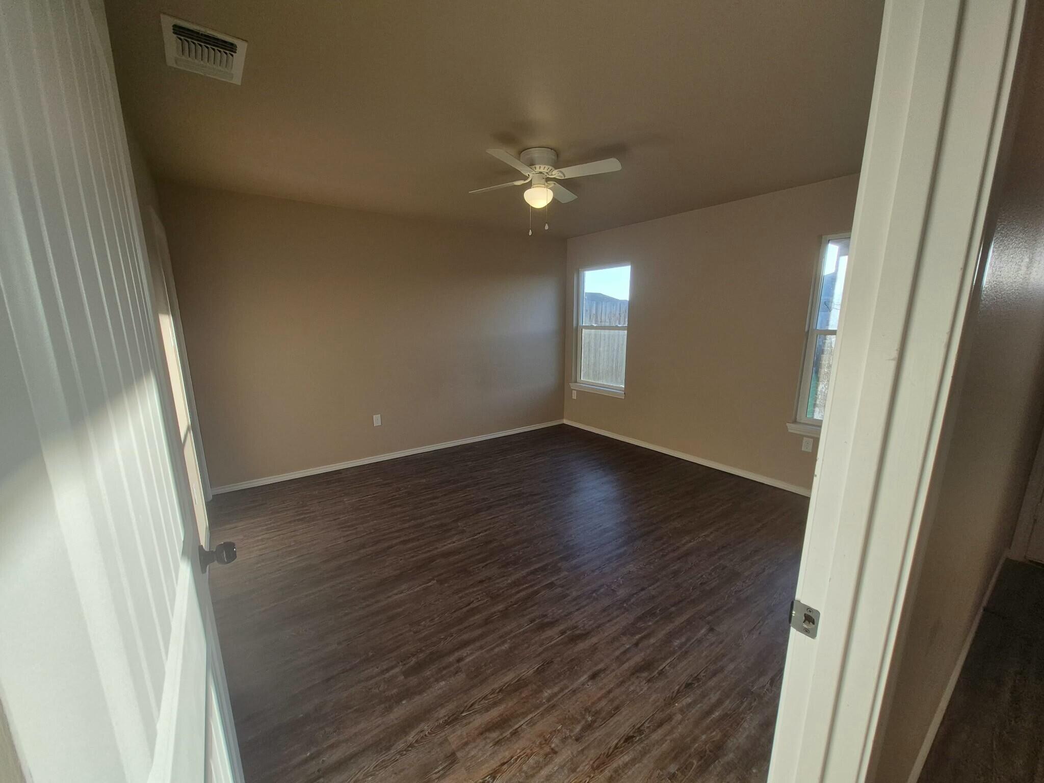 2506 Avenue P Lubbock, TX 79411 - Photo 4 of 11 an empty room with wooden floor and windows