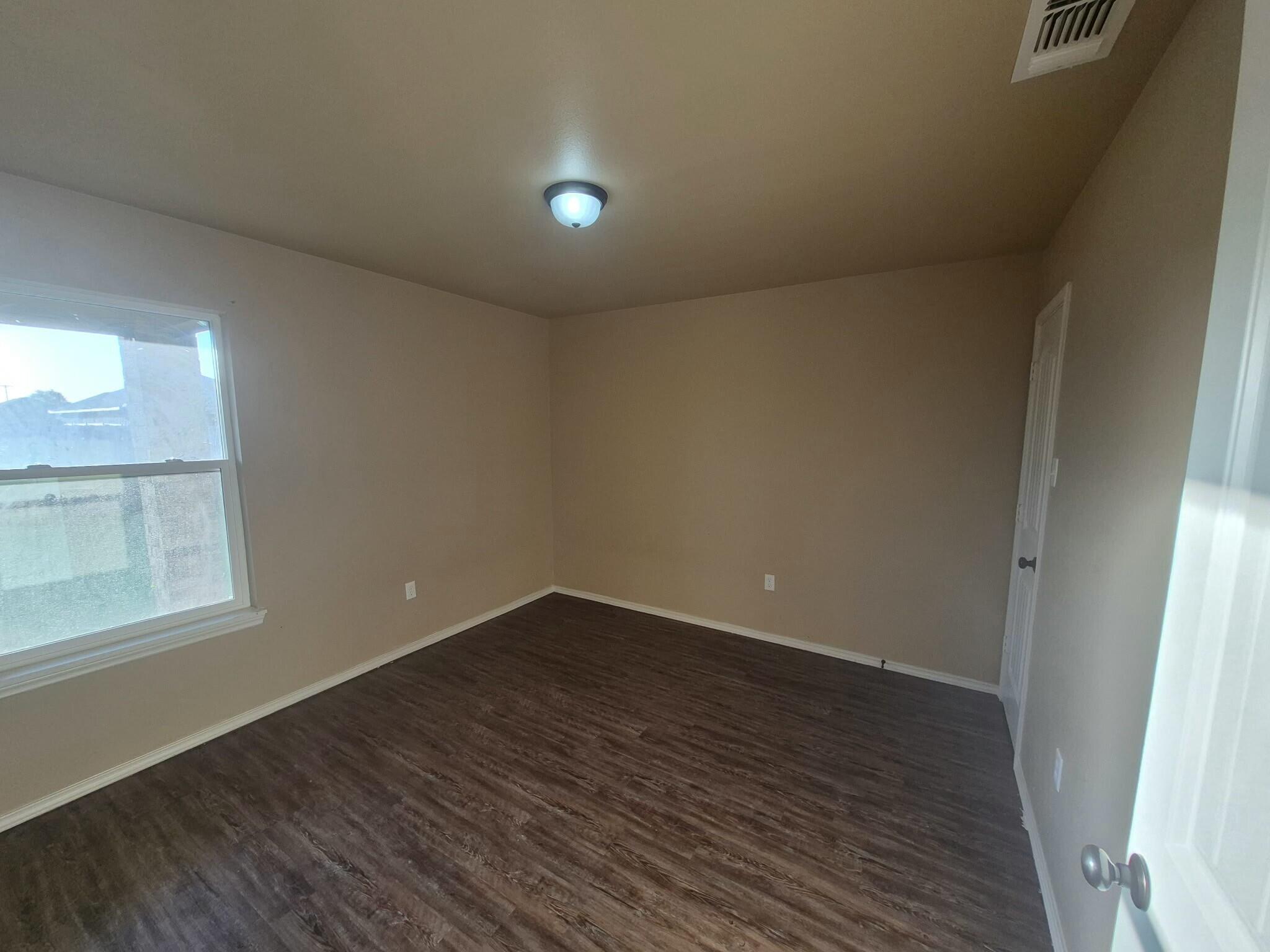 2506 Avenue P Lubbock, TX 79411 - Photo 10 of 11 an empty room with wooden floor and windows