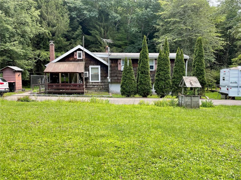 a front view of a house with swimming pool and garden