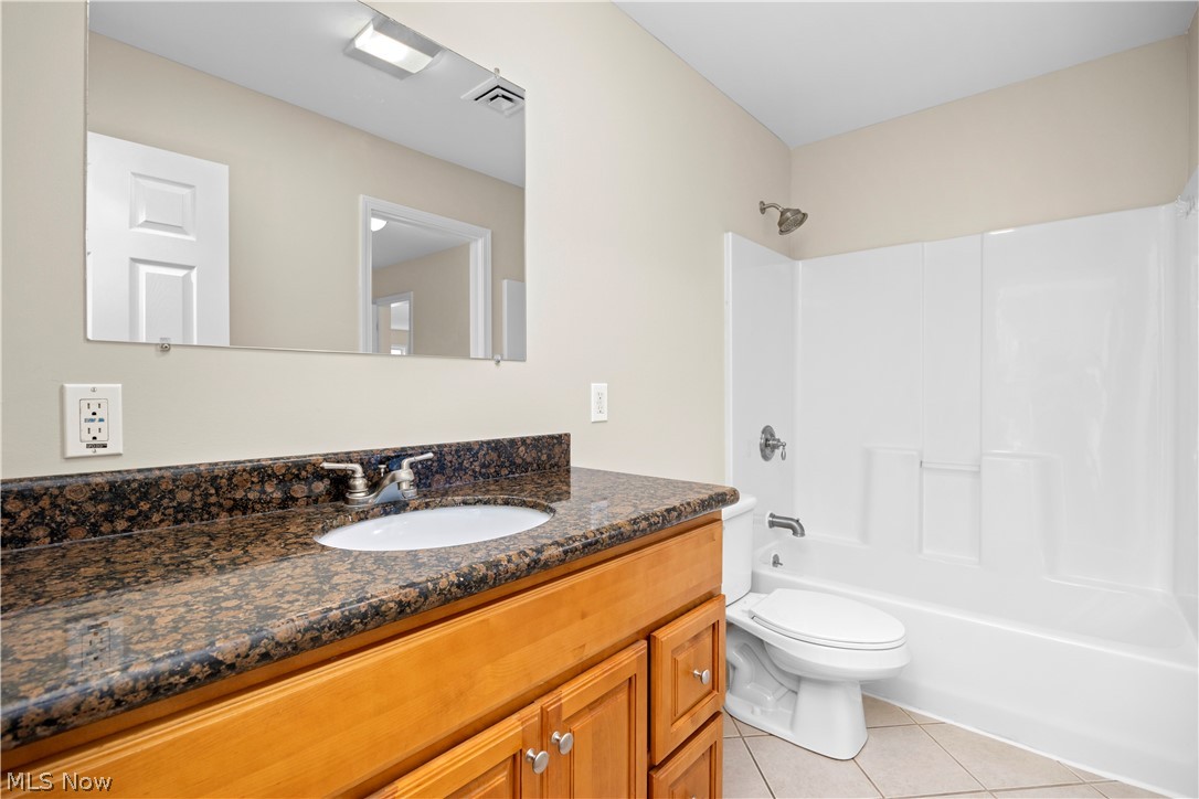 12452 Island Road Grafton, OH 44044 - Photo 26 of 39 Full bath featuring vanity, light tile patterned floors, and shower / bath combination