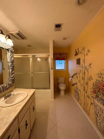 a spacious bathroom with a granite countertop sink a toilet and shower