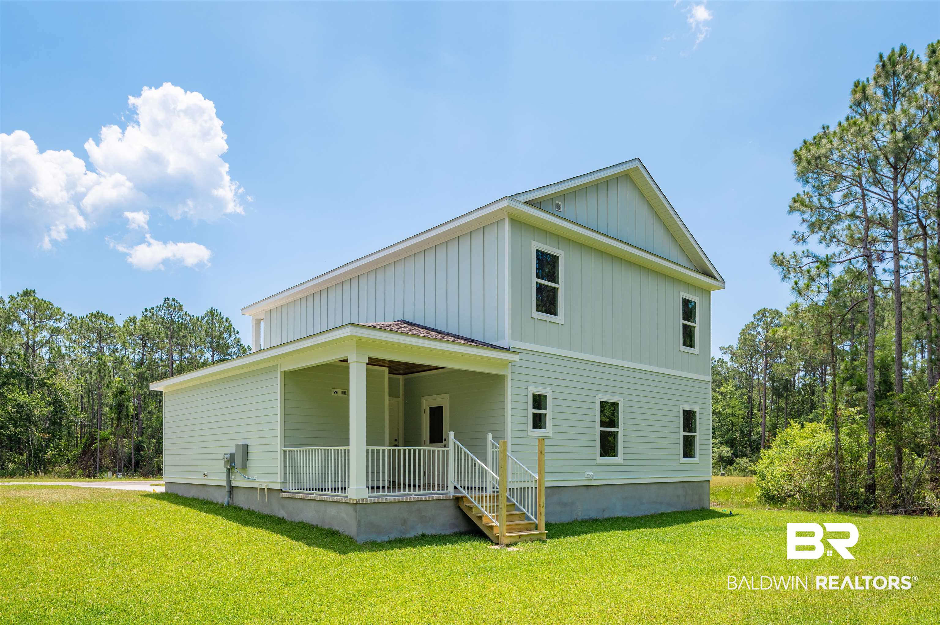 657 Island Way Gulf Shores, AL 36542 - Photo 35 of 59 View of front of house with board and batten siding, a front yard, and covered porch