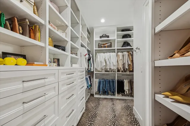 a view of walk in closet with clothes and shoes