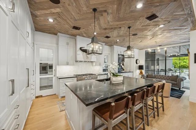 a kitchen with stainless steel appliances granite countertop a sink a stove and cabinets