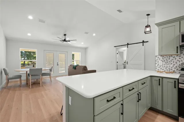 a kitchen with a sink a counter top space and living room view
