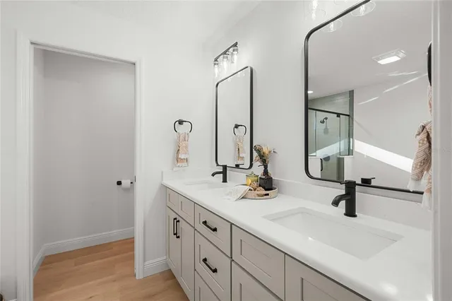 a bathroom with double vanity sink and a mirror