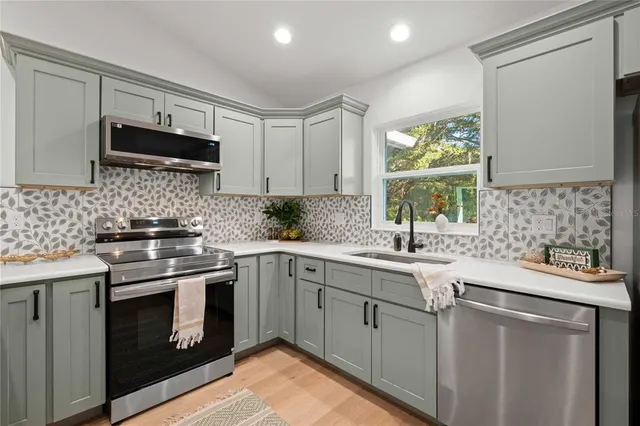 a kitchen with stainless steel appliances granite countertop a sink stove and refrigerator