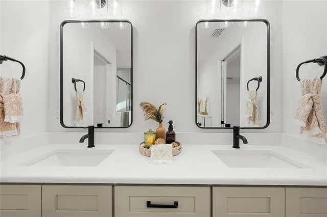 a bathroom with double vanity sinks and a mirror
