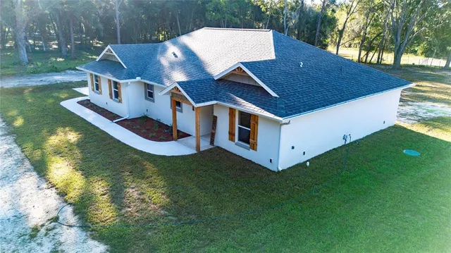 a view of house with backyard and trees around