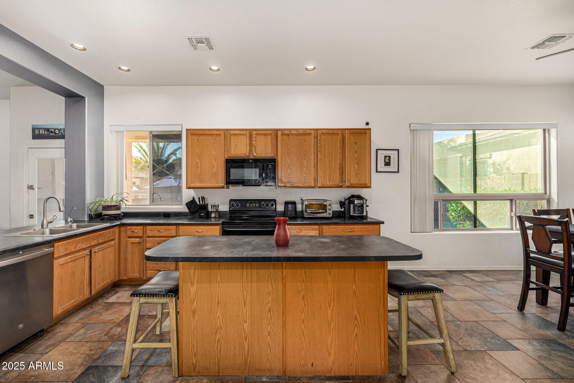 2026 North Rascon Loop Phoenix, AZ 85037 - Photo 11 of 38 a kitchen with stainless steel appliances granite countertop a stove a sink a microwave a dining table and chairs
