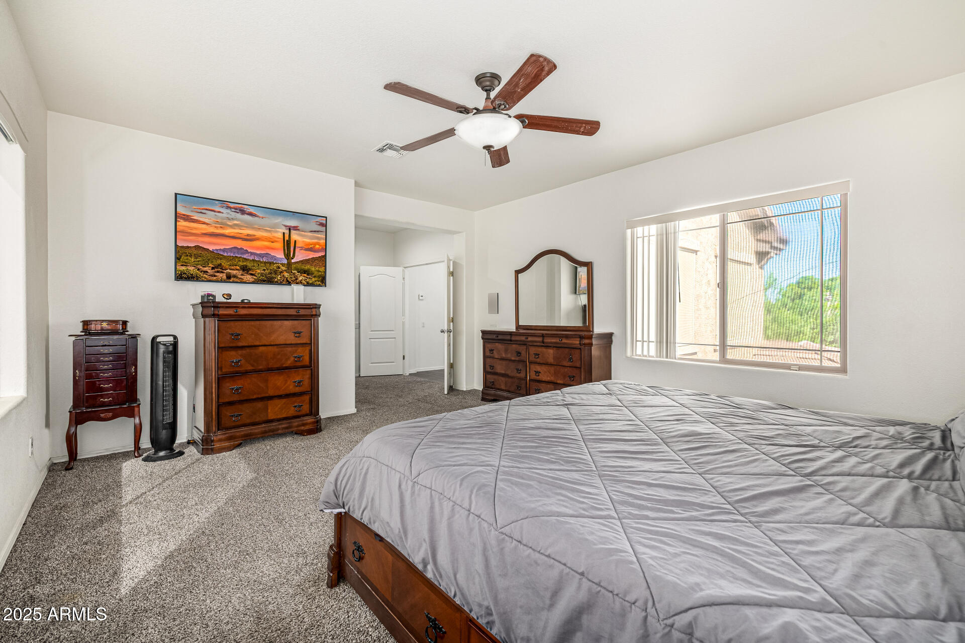 2026 North Rascon Loop Phoenix, AZ 85037 - Photo 4 of 38 a bedroom with a large bed and a flat screen tv