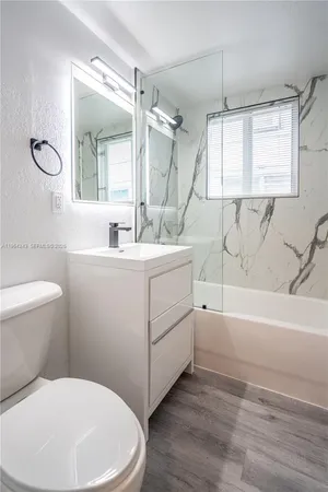 a bathroom with a sink toilet vanity and bathtub