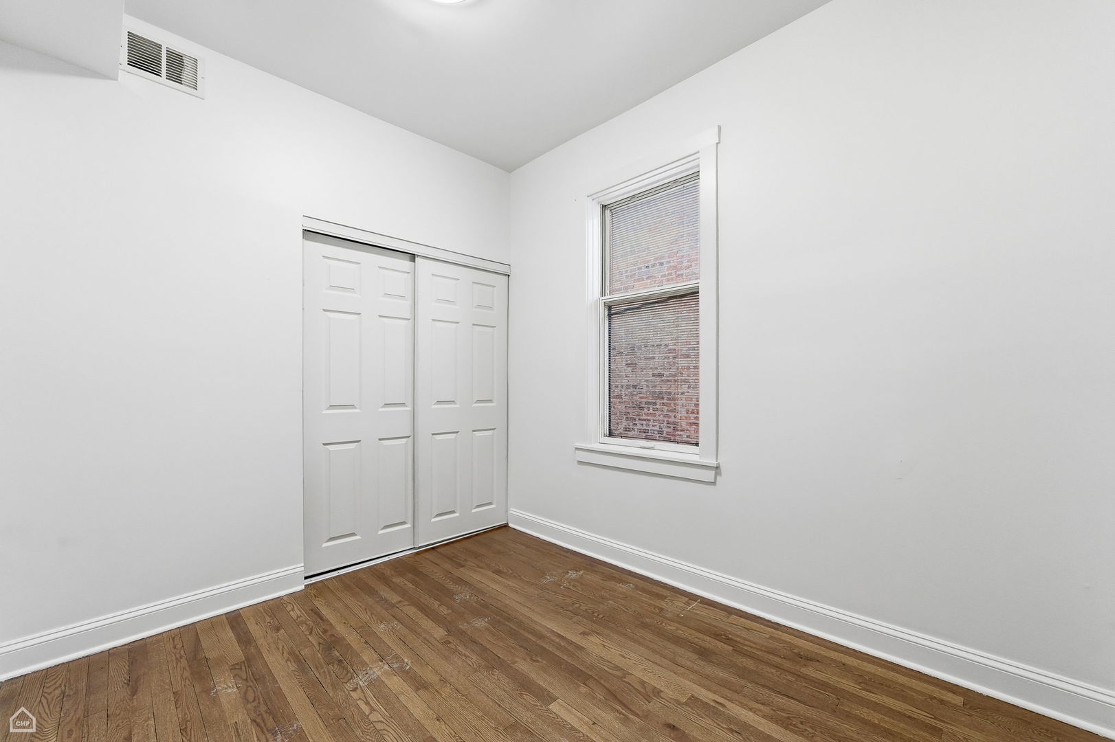 5250 West Grace Street, Unit 2 Chicago, IL 60641 - Photo 11 of 12 an empty room with wooden floor and window