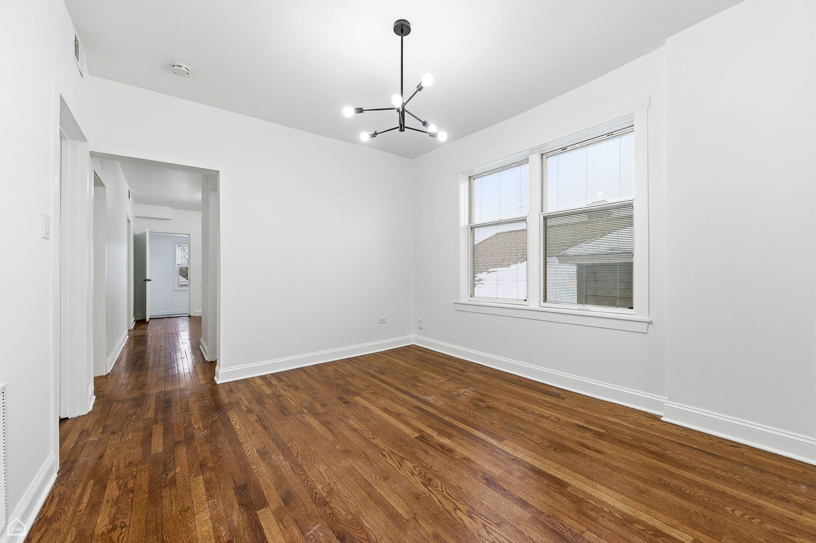5250 West Grace Street, Unit 2 Chicago, IL 60641 - Photo 9 of 12 a view of an empty room with wooden floor and a window