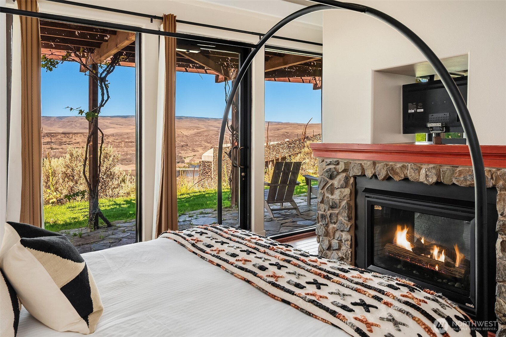 344 Silica Road Northwest, Unit 1 Quincy, WA 98848 - Photo 7 of 30 a living room with a fireplace a flat screen tv and a floor to ceiling window