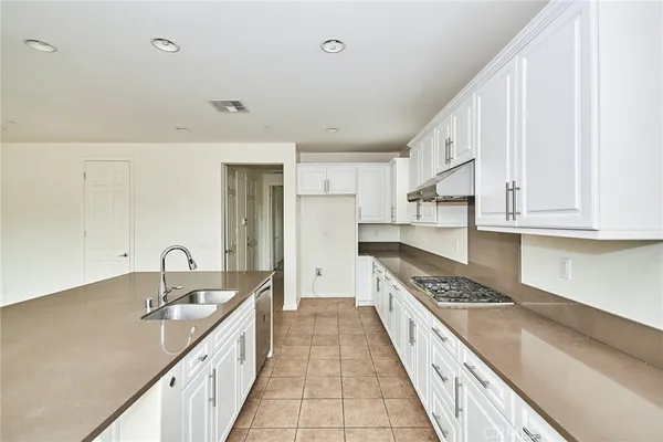 a kitchen with granite countertop a sink and cabinets