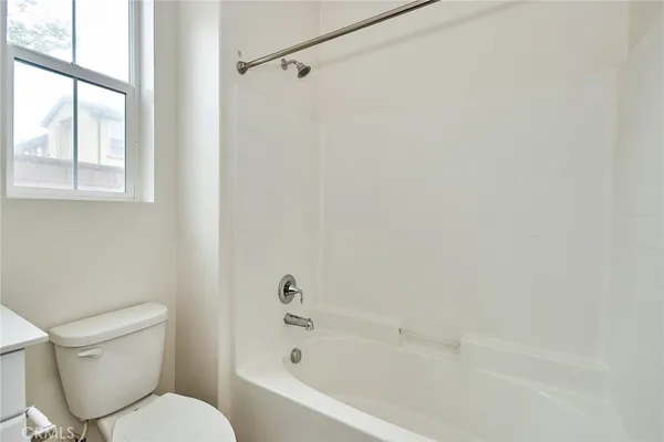a white toilet sitting next to a bath tub