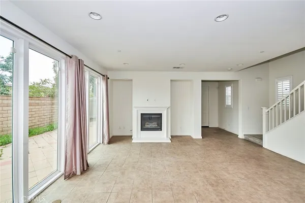 a view of an empty room with a fireplace and a window