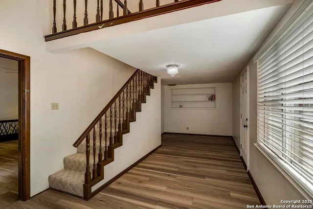 a view of a hallway with wooden floor and staircase