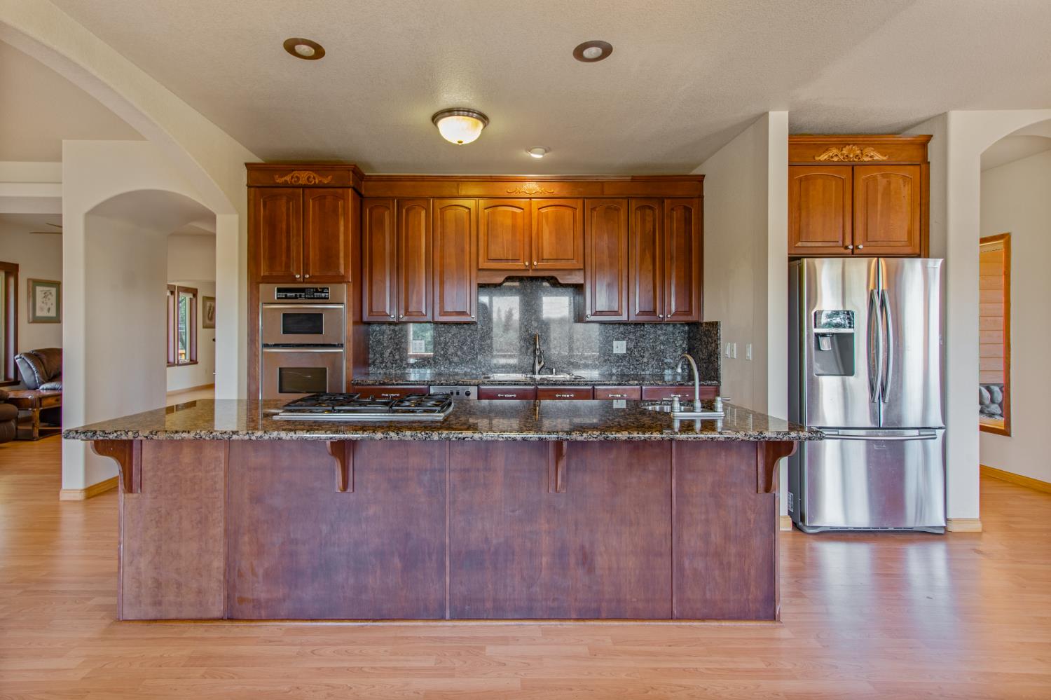 717 Swanson Lane Colfax, CA 95713 - Photo 5 of 44 a kitchen with wooden floors and refrigerator