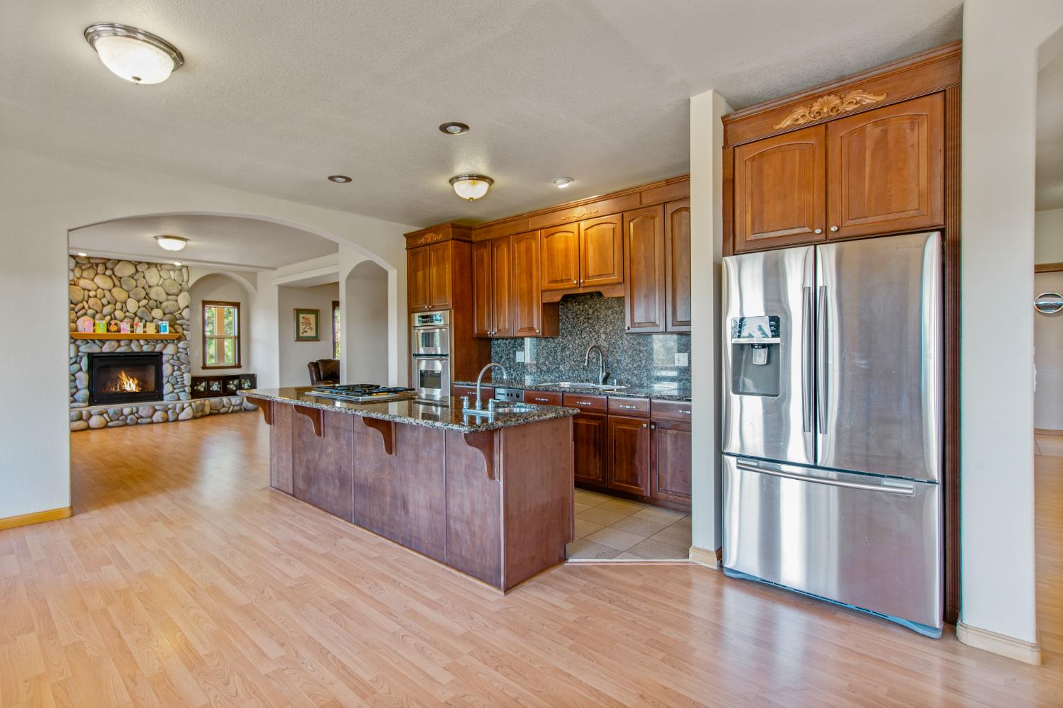 717 Swanson Lane Colfax, CA 95713 - Photo 7 of 44 a kitchen with stainless steel appliances granite countertop a refrigerator a stove and a wooden floors
