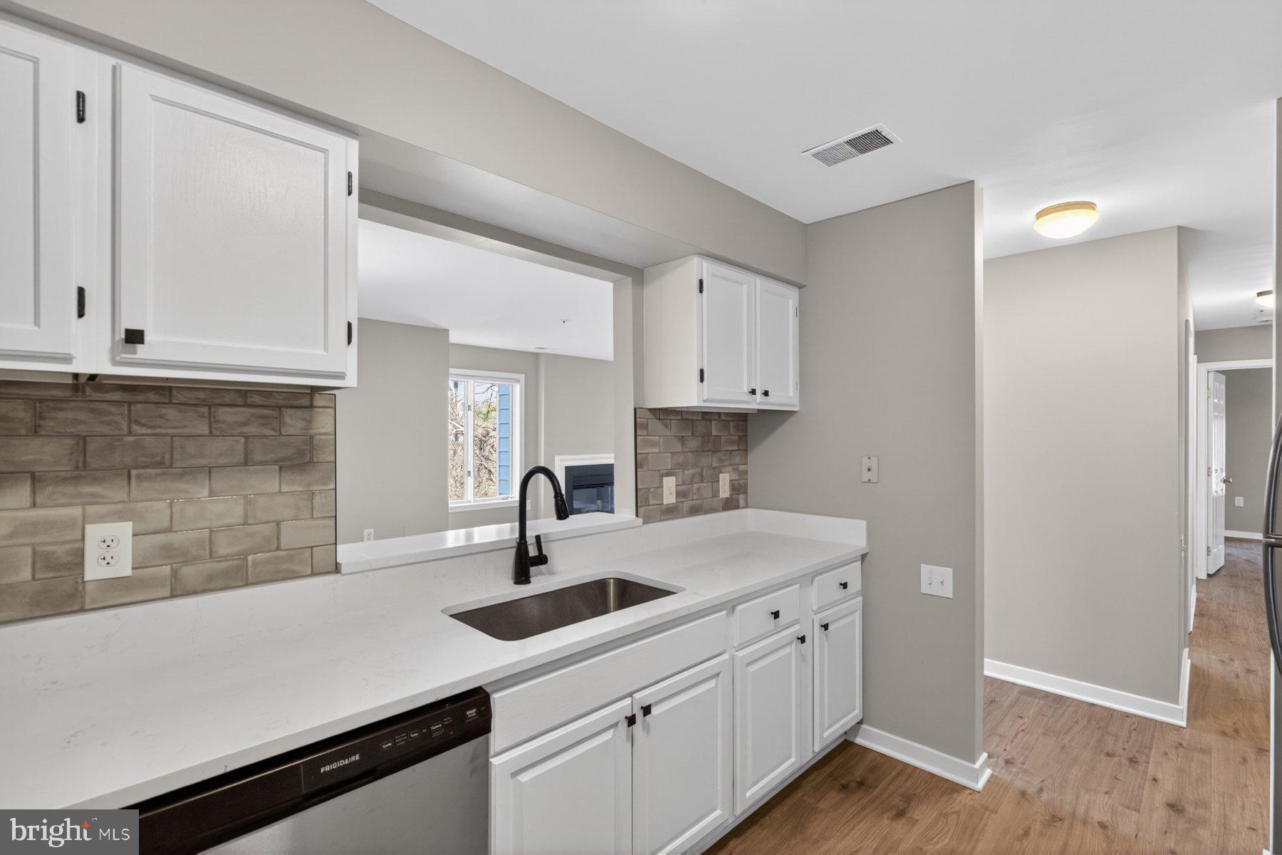 365 Pleasanton Road, Unit A13 Westminster, MD 21157 - Photo 11 of 25 a kitchen with white cabinets a sink and dishwasher