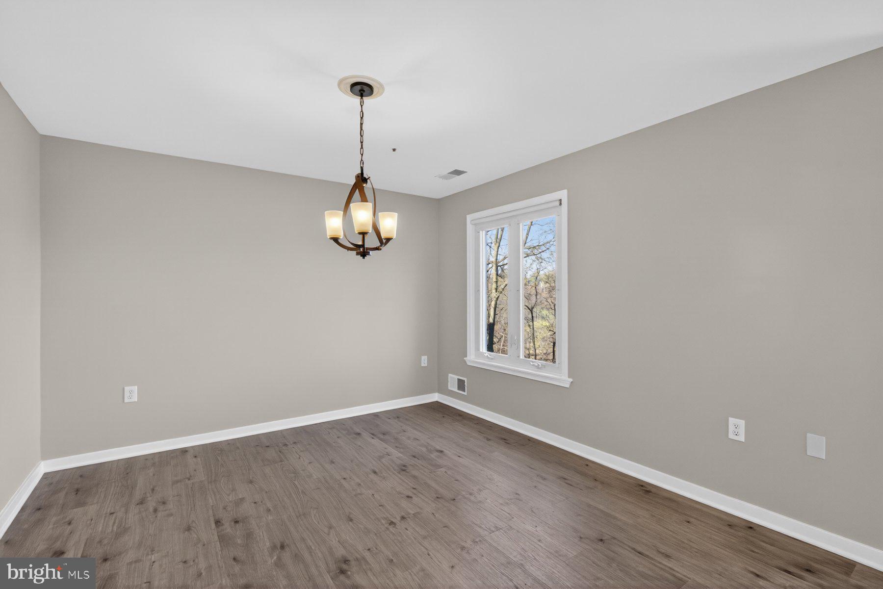 365 Pleasanton Road, Unit A13 Westminster, MD 21157 - Photo 5 of 25 a view of an empty room with wooden floor and a window