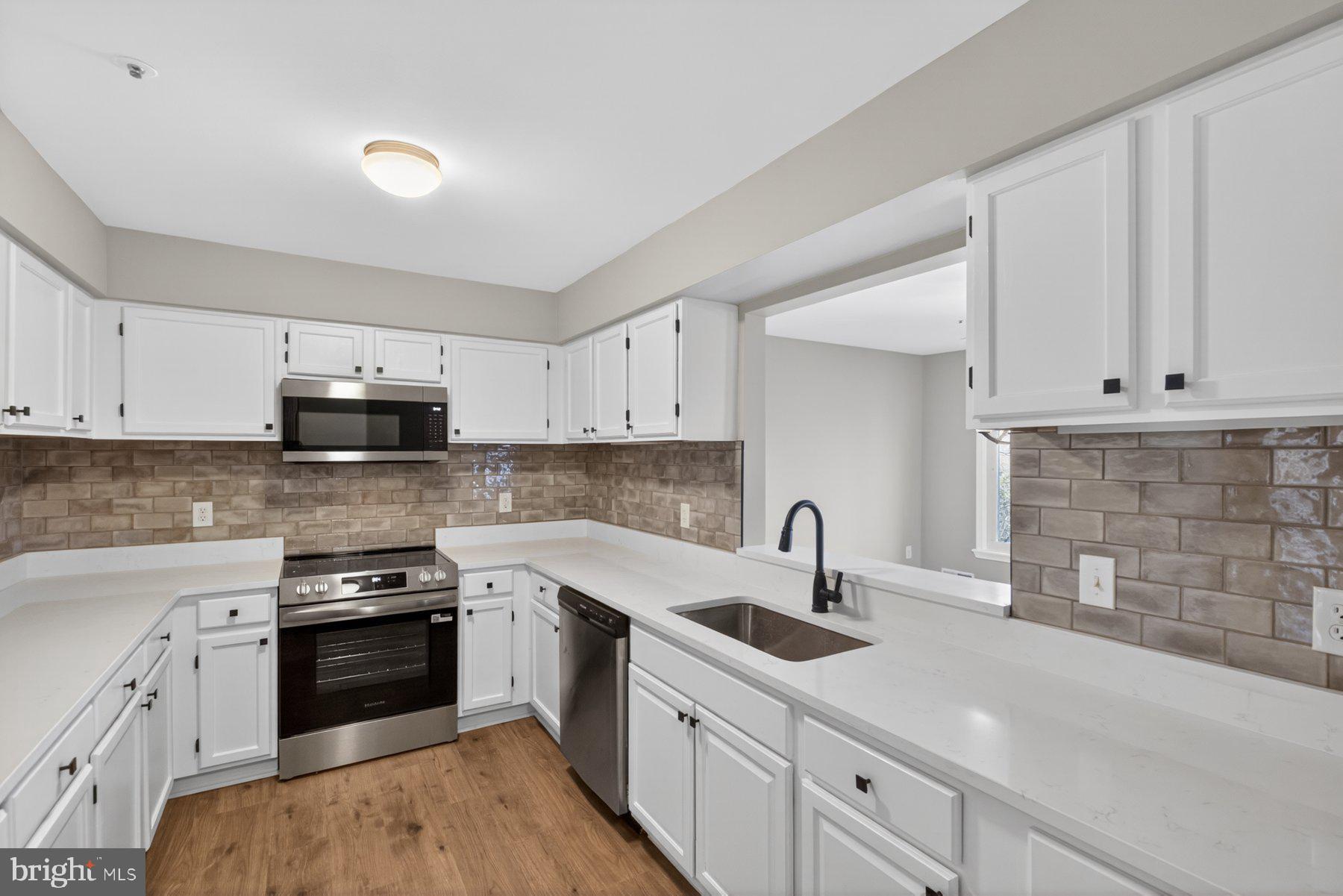 365 Pleasanton Road, Unit A13 Westminster, MD 21157 - Photo 8 of 25 a kitchen with white cabinets stainless steel appliances and sink