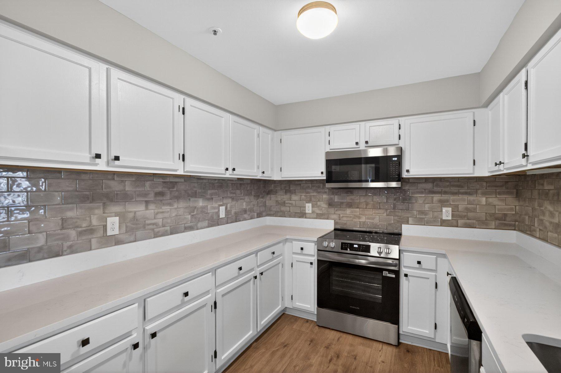 365 Pleasanton Road, Unit A13 Westminster, MD 21157 - Photo 9 of 25 a kitchen with granite countertop white cabinets and stainless steel appliances