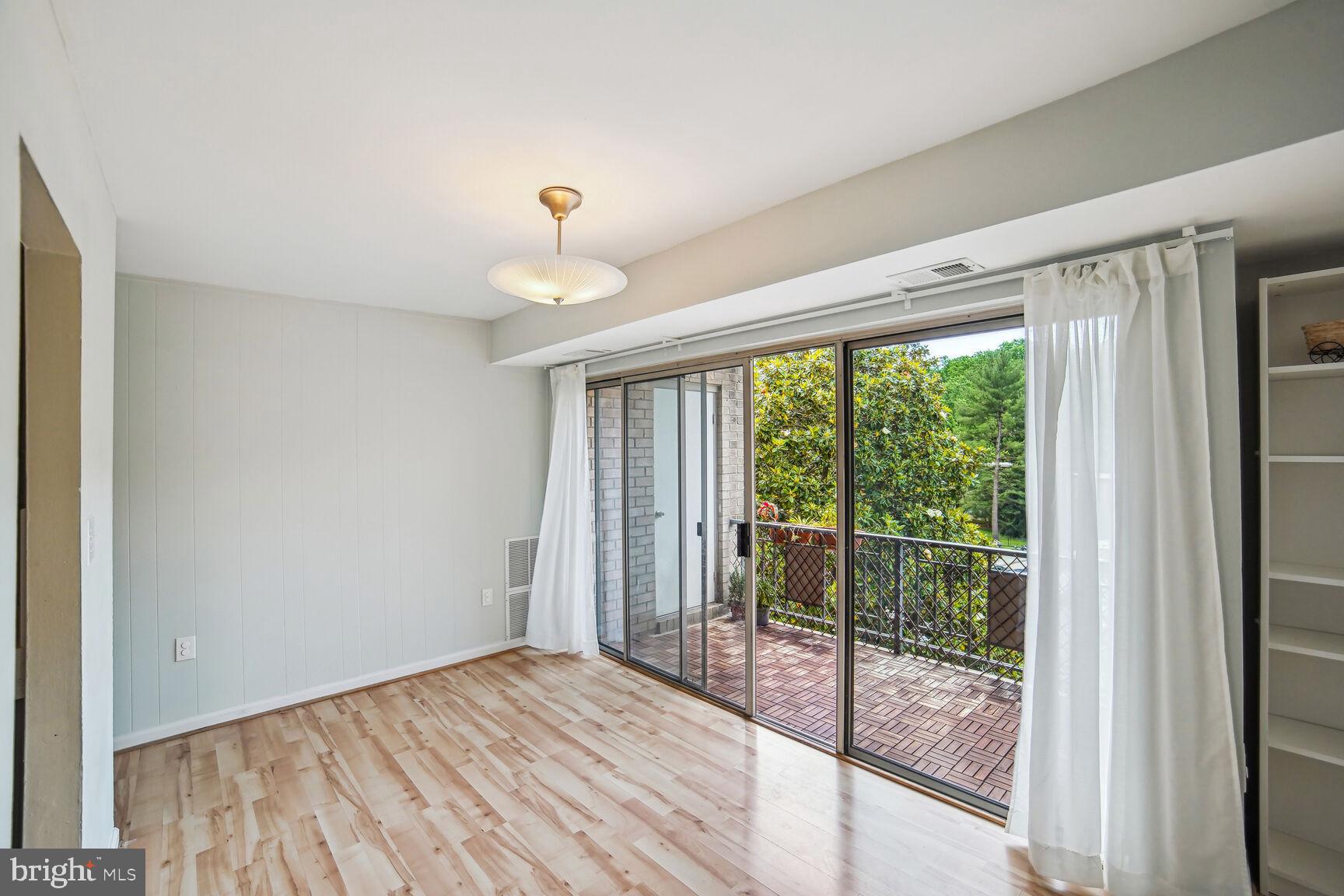 12200 Braxfield Court, Unit 209 Rockville, MD 20852 - Photo 4 of 17 a view of a room with wooden floor and balcony