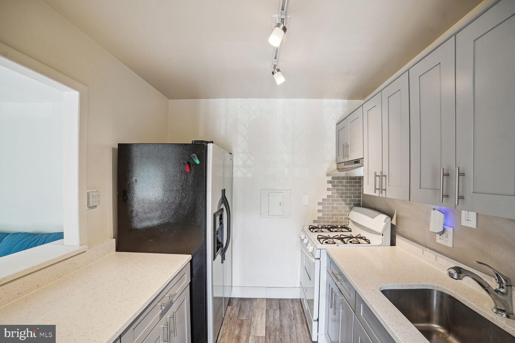 12200 Braxfield Court, Unit 209 Rockville, MD 20852 - Photo 8 of 17 a kitchen that has a microwave a stove and a refrigerator