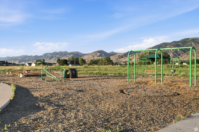 2257 South 1090 West, Unit 74 Nibley, UT 84321 - Photo 28 of 40 Community playground with wood chip ground covering, featuring a green swing set and climbing structure