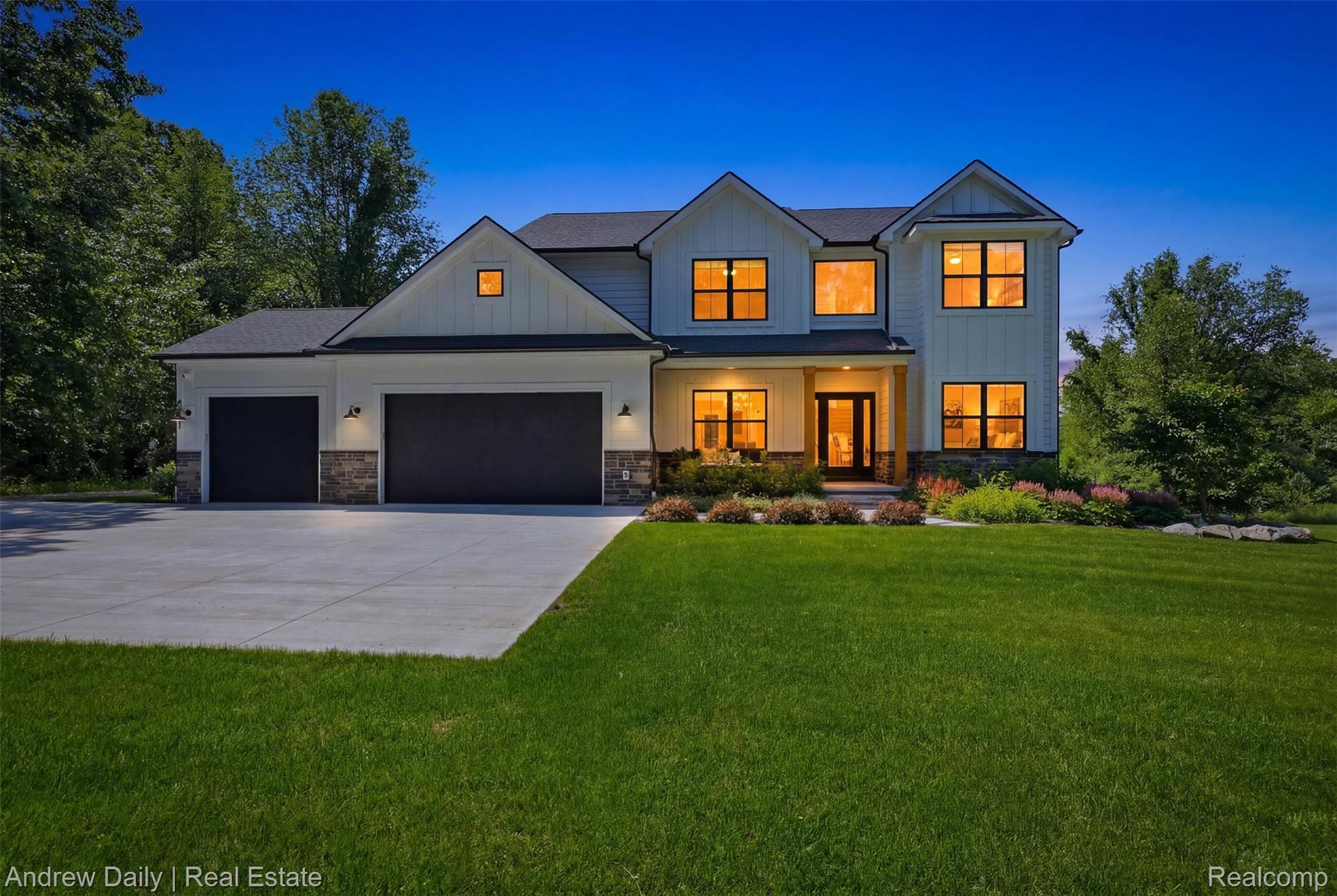 4661 Spears Road Pinckney, MI 48169 - Photo 1 of 56 Modern farmhouse exterior featuring white board and batten siding, dark framed windows, a covered entry, and a two-car garage