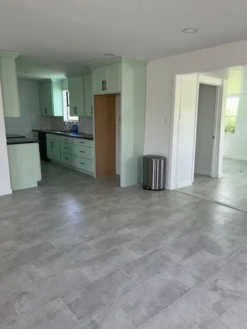 a view of kitchen with refrigerator and wooden floor